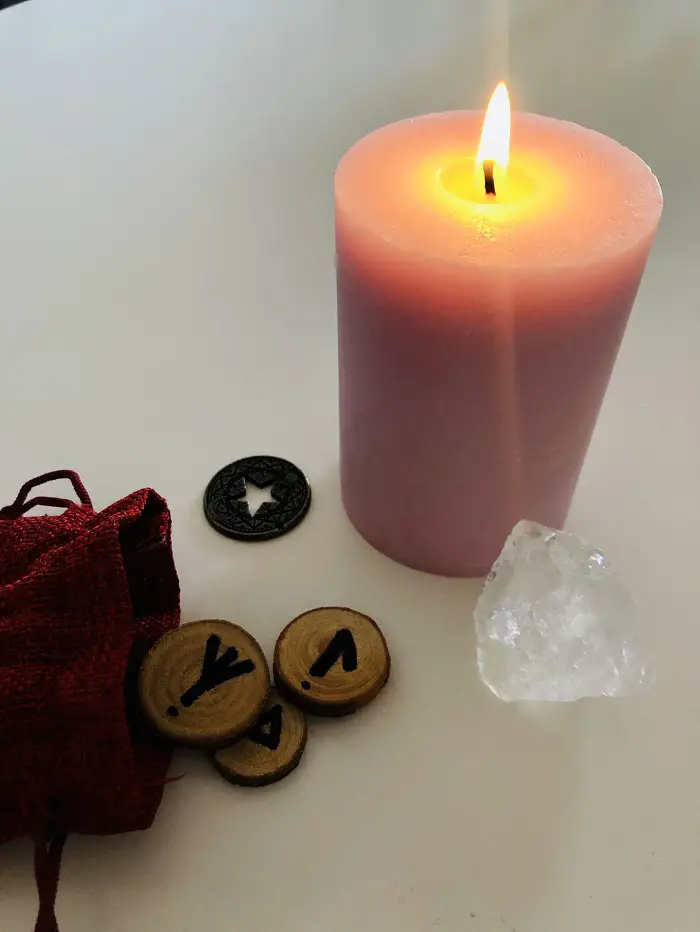 A picture of a candle and runes by Tina Caro